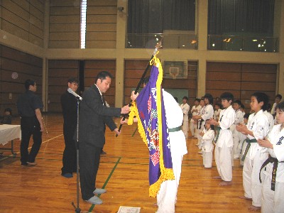 優勝した広島南地区大将 向井孝大に優勝旗が渡されました。