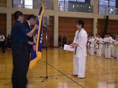 総合優勝の広島西地区チーム大将の小田昌平一級に優勝旗が渡されました。